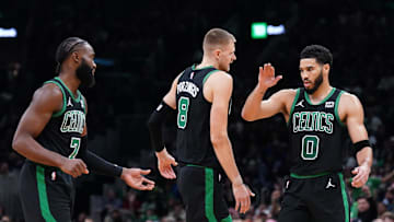 Nov 13, 2023; Boston, Massachusetts, USA; Boston Celtics forward Jayson Tatum (0), center Kristaps Porzingis (8) and guard Jaylen Brown (7) react after a play against th eNew York Knicks in the second quarter at TD Garden. Mandatory Credit: David Butler II-Imagn Images
