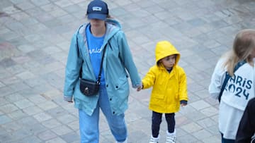 Jul 27, 2024; Paris, France; Tennis fans walk in rain jackets during the Paris 2024 Olympic Summer Games at Stade Roland Garros.