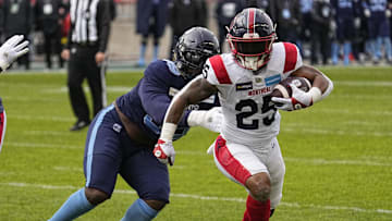 Nov 13, 2022; Toronto, Ontario, CAN; Montreal Alouettes running back Walter Fletcher (25) tries to outrun Toronto Argonauts defensive lineman Dewayne Hendrix (99) on a rushing play during the first half at BMO Field. Mandatory Credit: John E. Sokolowski-Imagn Images