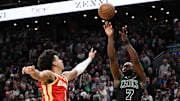 Jan 18, 2025; Boston, Massachusetts, USA; Boston Celtics guard Jaylen Brown (7) attempts a three-point basket against Atlanta Hawks forward Jalen Johnson (1) during the fourth quarter at the TD Garden. Mandatory Credit: Brian Fluharty-Imagn Images